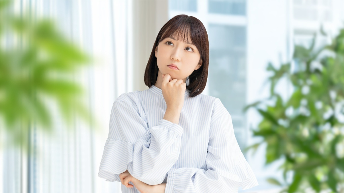 大人でも歯列矯正はできるのか顎に手を当てて考える女性