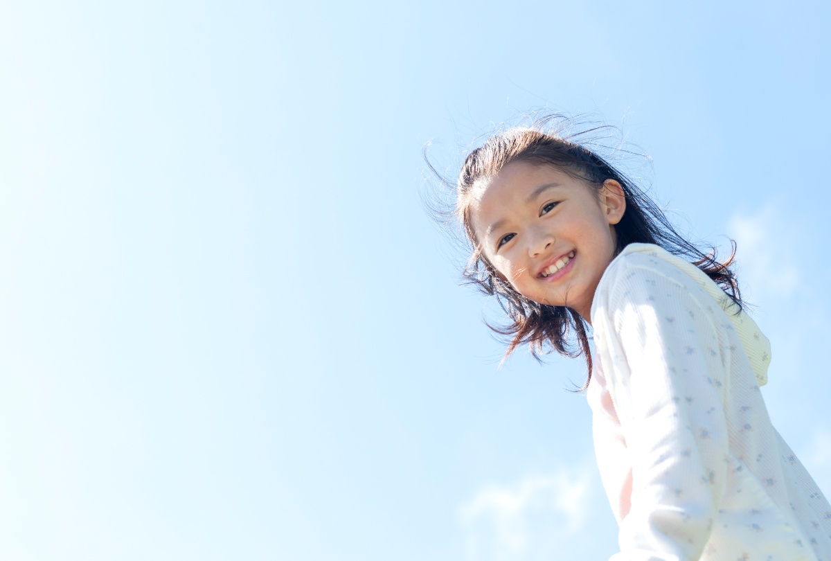 青空の下の笑顔の女の子