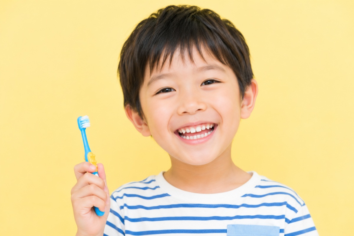右手に歯ブラシを持った笑顔の子ども